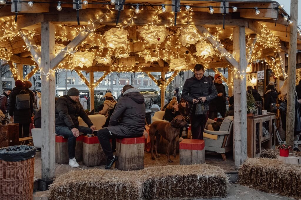 Winter scene at Zurich Christmas market with decorated seating area, people, and festive lights.